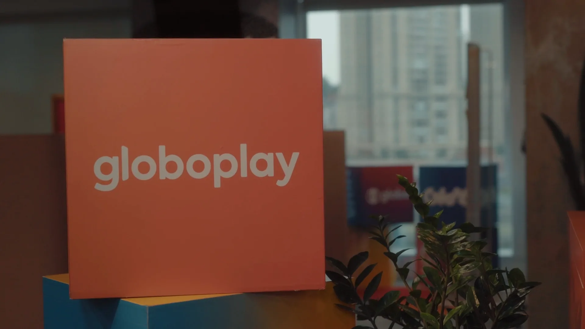 Placa laranja com a marca Globoplay no escritório da Globo