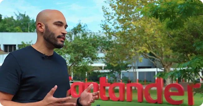 Entrevistado do projeto diante do letreiro do Santander