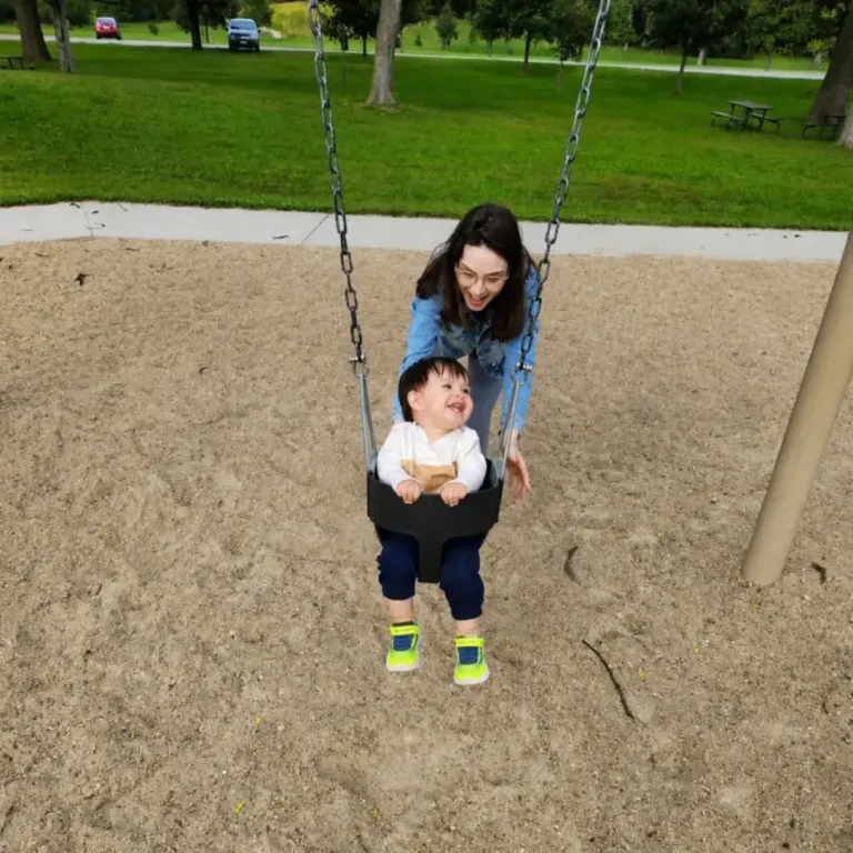 Sara Oliveira empurra o balanço do filho Pedro em um parque