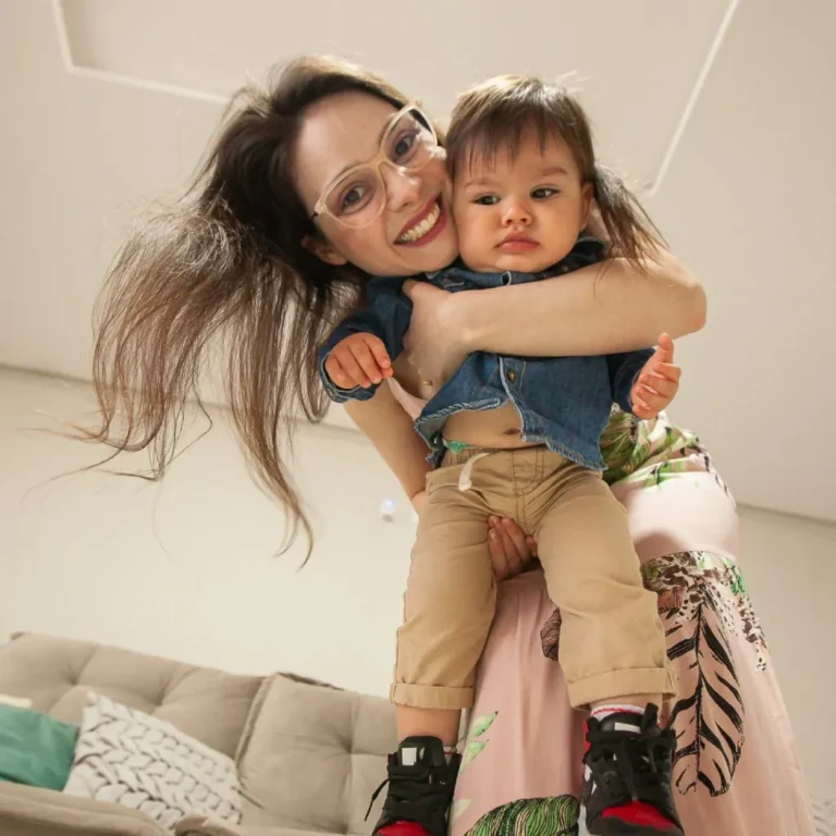 Sara Oliveira sorrindo abraçada ao filho Pedro em casa
